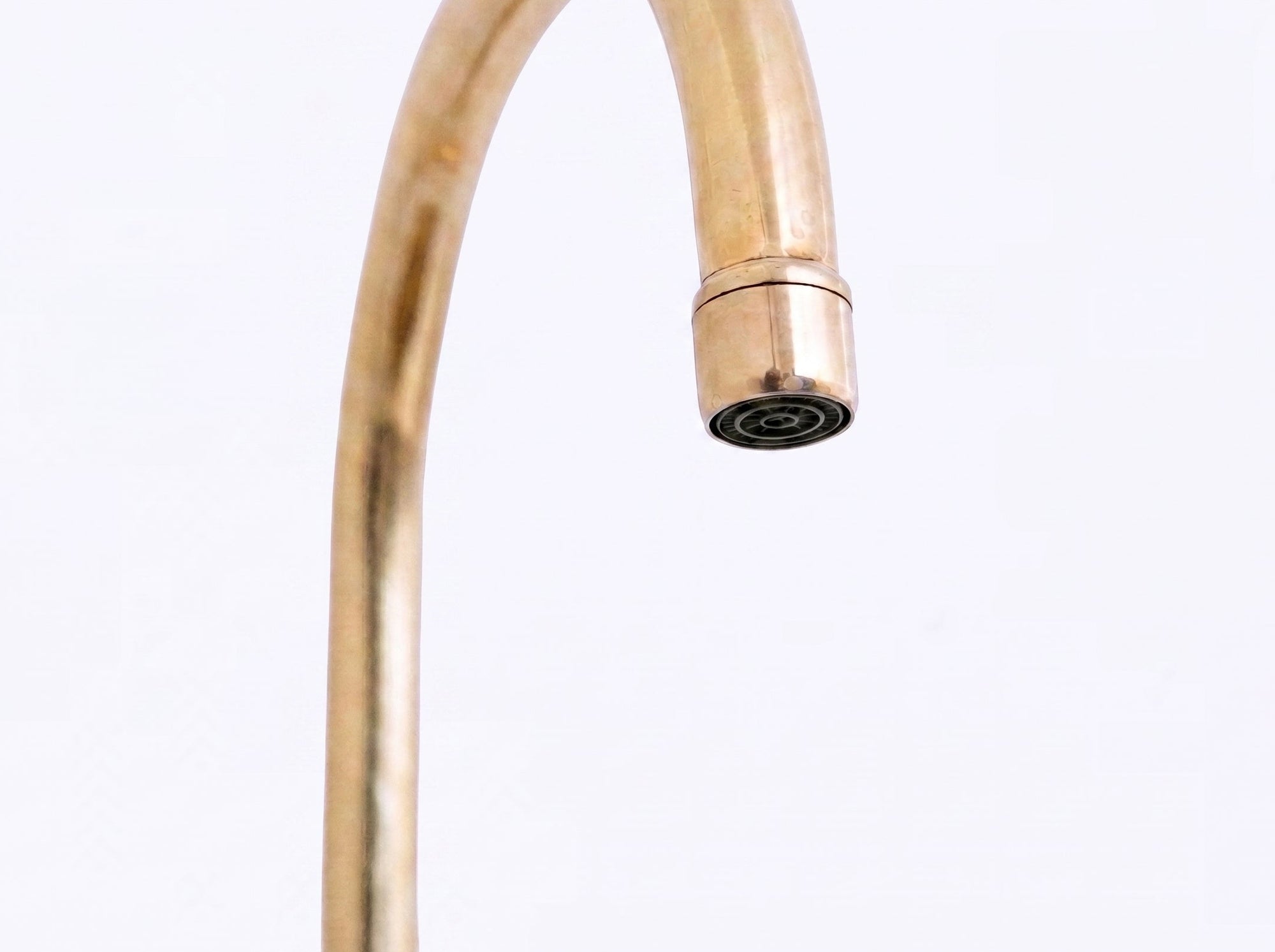 A close-up of a brass faucet spout with a cylindrical head, shown against a plain white background.